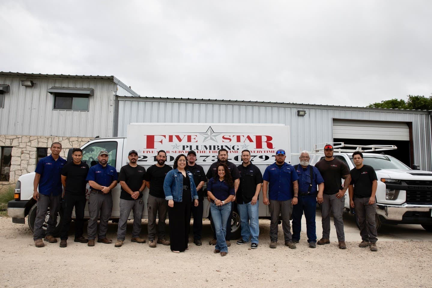 Five Star Plumbing team in front of service trucks